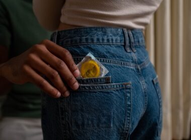 Person Pulling a Condom Out of a Pocket