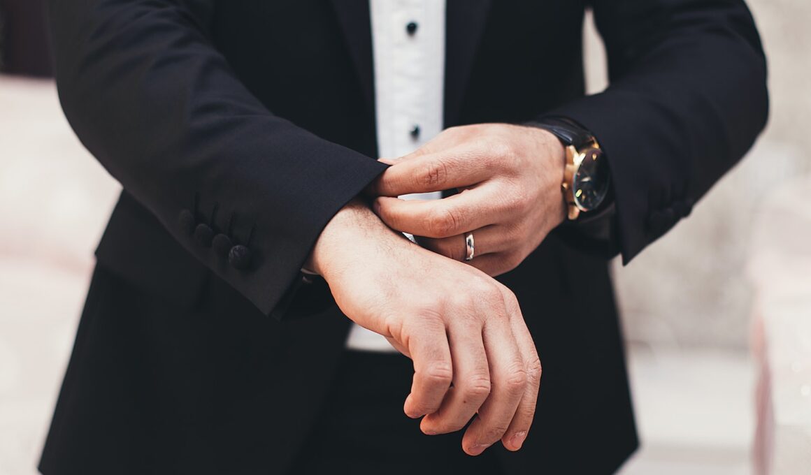 A man's hands adjusting the cuffs of his black suit