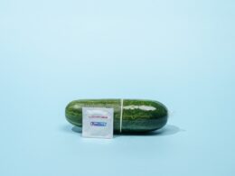 a cucumber with a label on it sitting on a blue surface