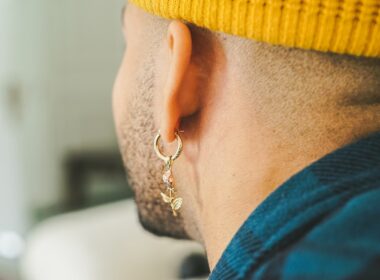 person wearing gold-colored unpaired earring