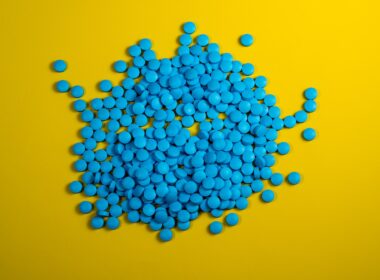 a pile of blue pills on a yellow background